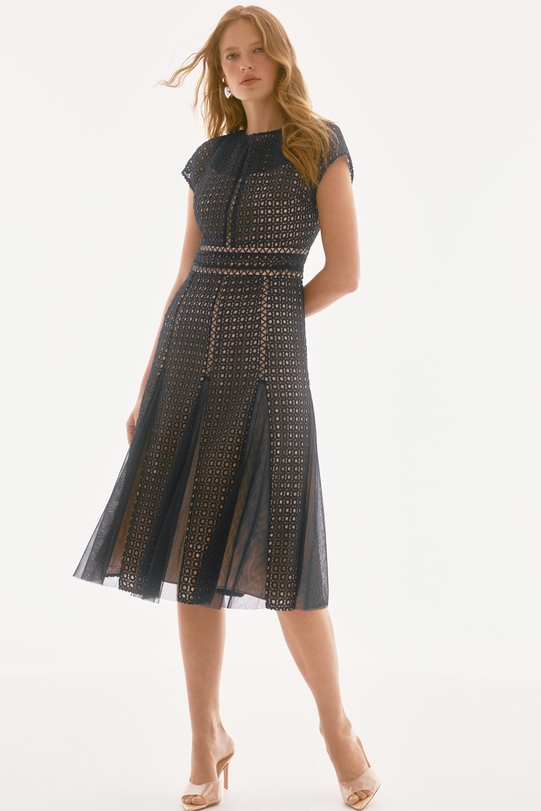 A model wearing a Joseph Ribkoff navy midi A-line dress with short, straight sleeves and a round neckline, adorned with a geometric pattern and belted embellishments.