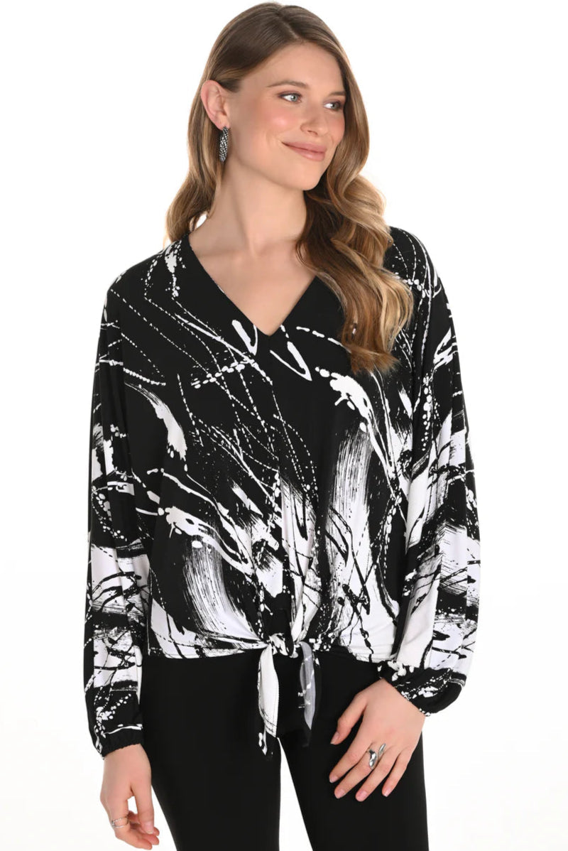 Woman wearing a black and white patterned blouse on a white background