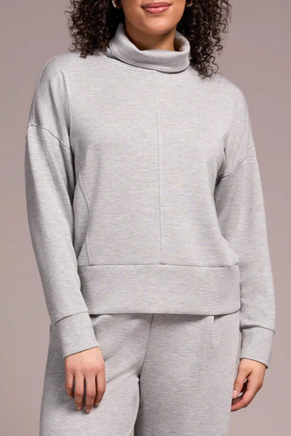 Person wearing a gray tracksuit against a plain background